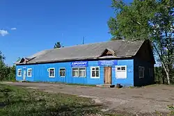 Photographie d'un bâtiment en bois bleu ne possédant pas d'étage, avec un toit en pente.