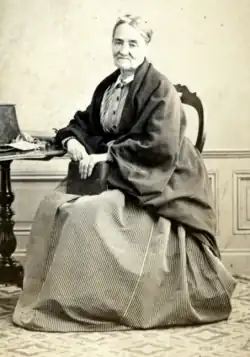 Photographie (portrait) de Zéline Reclus assise à une table.