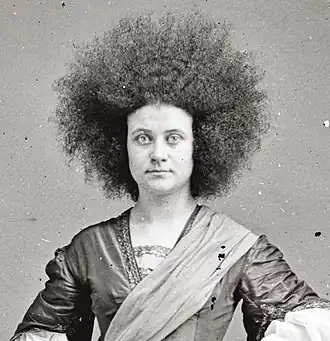 alternative1=Photographie; portrait trois quart d'une jeune femme aux longs cheveux crépus.