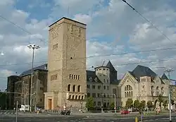 Photographie d'un bâtiment ancien dont une tour se dégage.