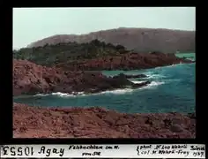 Photographie colorisée de 1937 : mer et roches rouges.