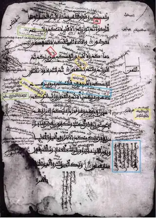 Description d'image : manuscrit usé sur fond noir, représentant 12 versets du Coran calligraphiés, entourés d'annotations abondantes entre les lignes ou dans la marge.